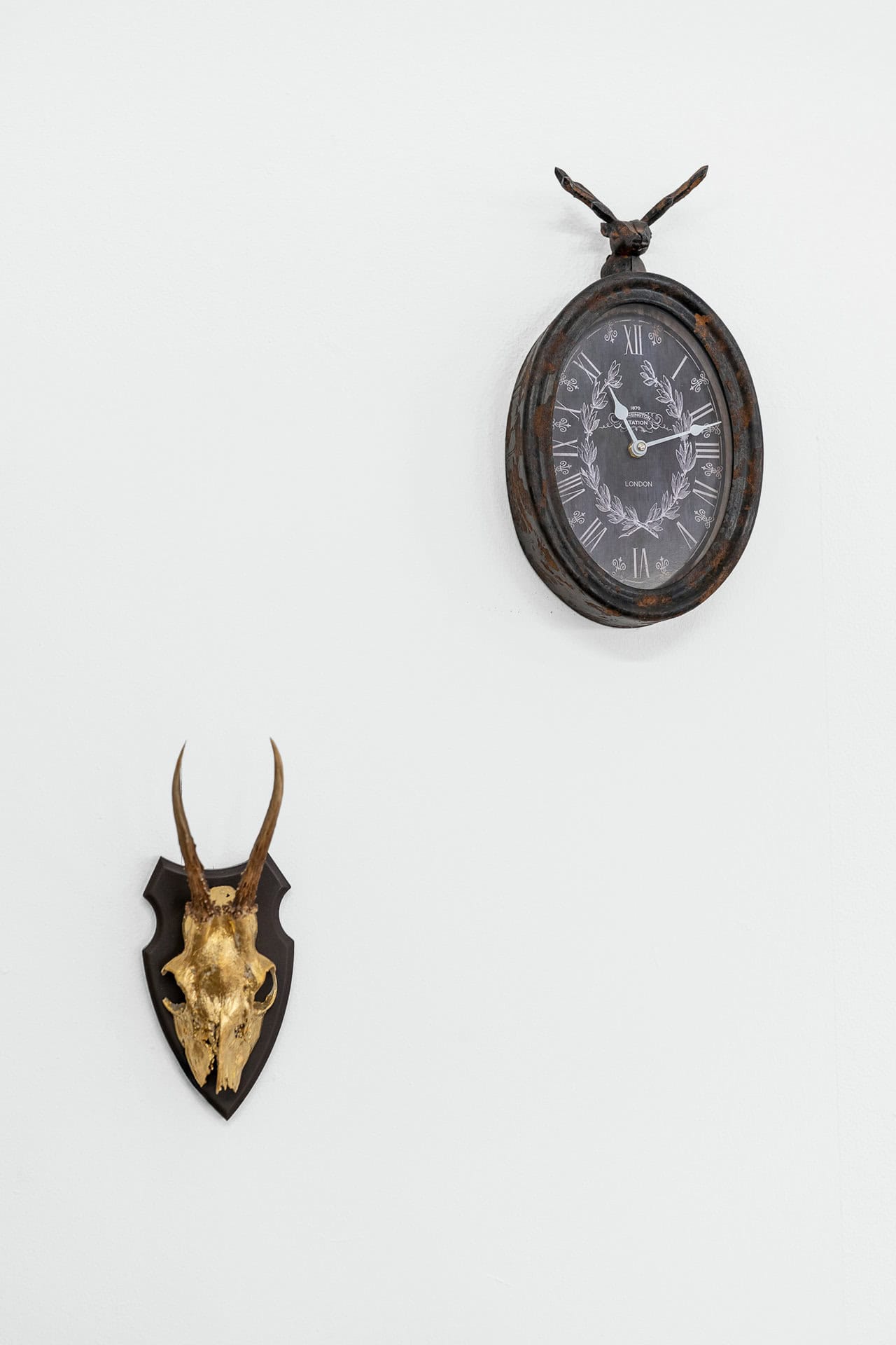 Ladendeko Uhr und goldenes Hirschgeweih